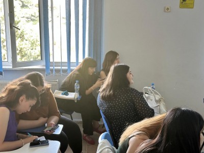 in the foreground the teacher conducting the class . Click to zoom the picture.